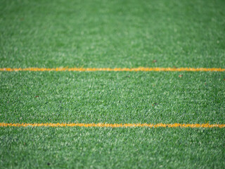 Close-up of artificial turf with yellow lines on a soccer field