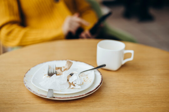 Cozy coffee shop moment with used crockery on wooden table