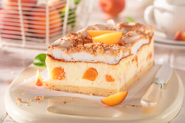 Homemade peach cheesecake served on bright kitchen.