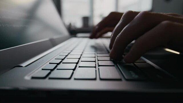 Close-up view of hands of unrecognisable professional programmer writing code on laptop during workday