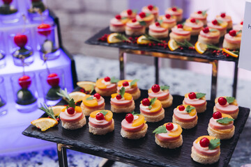Catering table, beautifully decorated banquet with variety different food snacks appetizers on christmas corporate birthday party event or wedding celebration, canape, salad, delicatessen setting