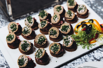 Catering table, beautifully decorated banquet with variety different food snacks appetizers on christmas corporate birthday party event or wedding celebration, canape, salad, delicatessen setting