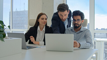 Diverse team corporate coworkers working laptops in office male business coach mentor boss businessman helping employees with computer work training new workers help interns check explain data project