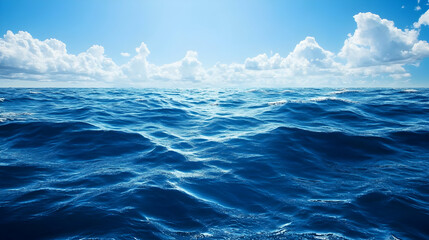 Calm Ocean Waves Under Bright Blue Sky with White Clouds