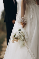 the bride holds a beautiful wedding bouquet in her hands. Wedding celebration.