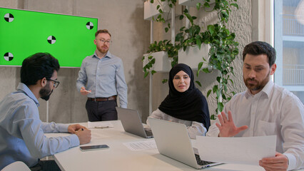 Team employees corporate staff businessmen multiracial businesswoman discuss documents at office conference ceo manager leading business meeting show presentation on green screen chroma key copy space