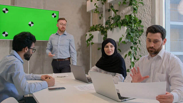 Team employees corporate staff businessmen multiracial businesswoman discuss documents at office conference ceo manager leading business meeting show presentation on green screen chroma key copy space - Powered by Adobe
