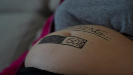 Pregnant belly with a 60% loading bar painted, symbolizing 24 weeks pregnancy