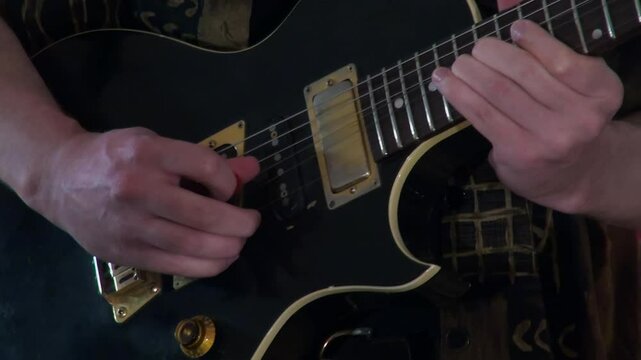 Close up body and neck: Musician plays black electric guitar solo