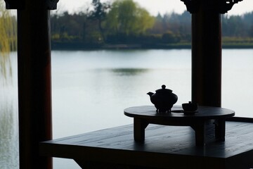 Tea in a Pagoda: A serene pagoda overlooking a lake, with a tea table set on a wooden platform, offering a peaceful view