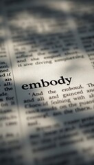 Close-up of the word 'embody' in a book with shadow overlay