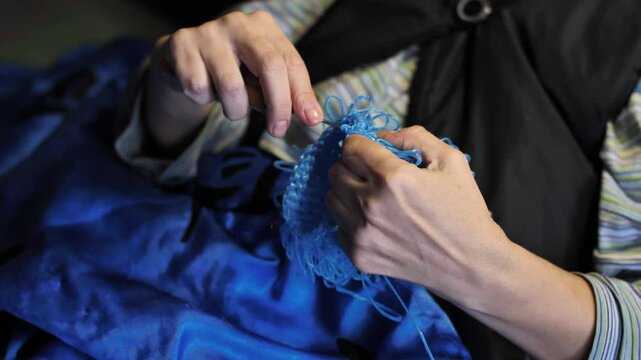 Close-up. Woman's hands crocheting a product made of blue polypropylene nylon plastic twine. Hobby-knitting and handmade crafts for relaxation and mental health