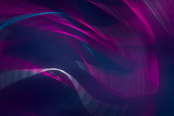 Abstract dark purple background with glowing neon waves of light