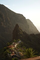 Naklejka premium Picturesque view of La Masca village in Tenerife, Spain, nestled among dramatic volcanic peaks and lush greenery under a clear blue sky.