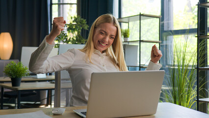 Excited happy Caucasian businesswoman woman female winner win online bet on laptop computer...