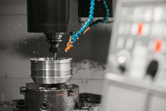 CNC milling machine cutting aluminium automotive part with a coolant liquid. Hi-Technology manufacturing process. 