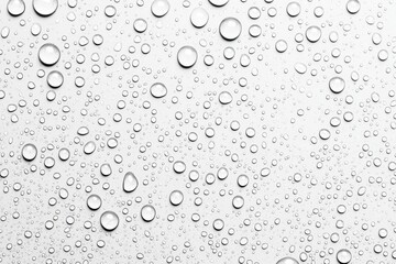Clear Water Droplets on a Clean Transparent Surface with Soft Background Texture