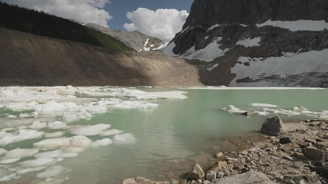 A serene glacial lake with floating ice in Mount Edith Cavell, Canadian Rockies