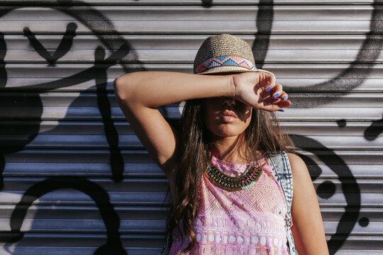 Fashionable woman posing against a graffiti backdrop