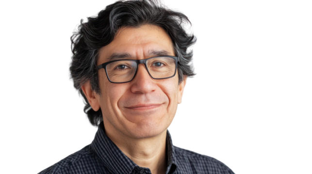 A smiling middle-aged man with glasses and curly hair, wearing a black patterned shirt, posing confidently against a white background.