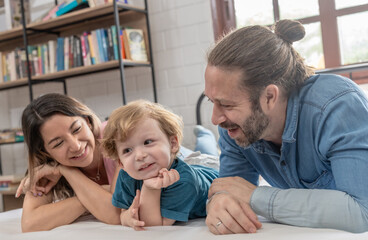 Obraz premium Family enjoys quality time together indoors in a cozy setting while engaging with a child