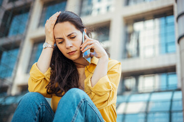 Distraught Woman Talking on Phone Outdoors With a Concerned Expression