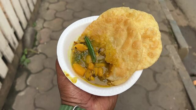 Khasta kochuris served with aloo sabji in disposable plate during morning.
