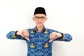 Government worker man wearing korpri batik showing thumb down dislike gesture, disappointed and...