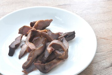fried salty slice ox tungue or Gyutan and pepper arranging on white plate 