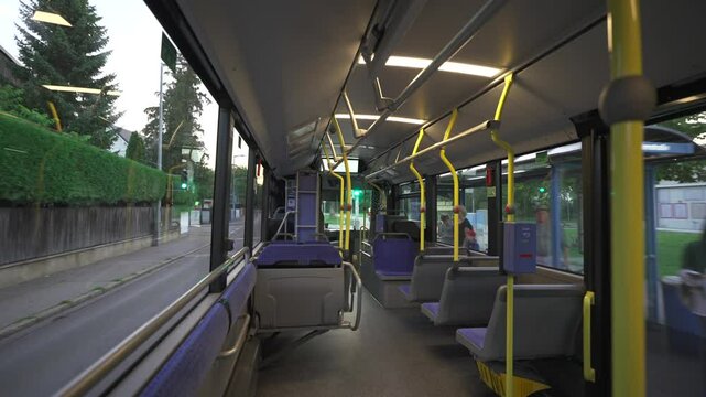 Quiet early morning in Munich, Germany. Empty, clean, eco-friendly MVV commuter bus awaits at urban stop in Trudering. Modern design, empty seats, and peaceful streets reflect efficient transit. 