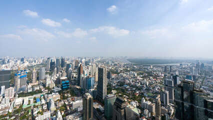 Fototapeta premium A panoramic view of a bustling city featuring skyscraper and a mix of urban building. The clear sky provide a stunning backdrop to the dynamic landscape below. Bangkok, Thailand.