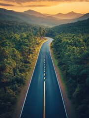 Fototapeta premium Scenic Highway Winding Through Lush Green Forest towards Mountains at Sunset