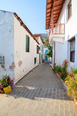 Narrow tourist streets of the Turkish city of Kas with white houses and colored windows. Beautiful ethnic resort town.