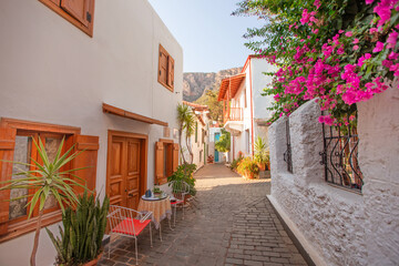 Narrow tourist streets of the Turkish city of Kas with white houses and colored windows. Beautiful ethnic resort town.
