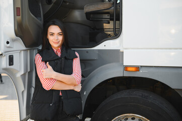 Portrait of a beautiful woman truck driver standing in the parking lot