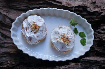 Donuts in a white plate on a wooden background
