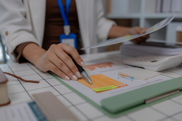 there are a lot if documents pied up on the desk if the data analysis team leader, an employee sits...