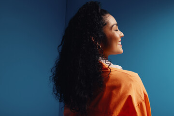 Portrait of a young woman with eyes closed in a vibrant, monochromatic studio setting