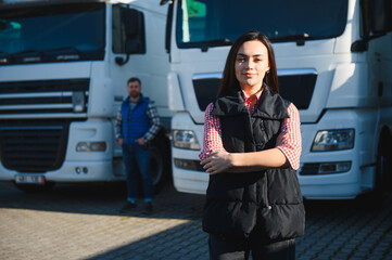 Portrait of a beautiful woman truck driver standing in the parking lot