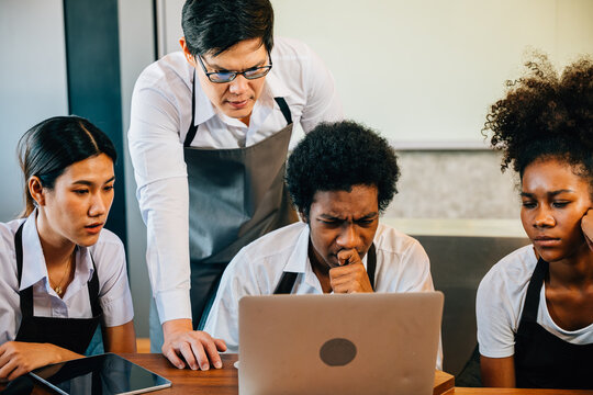Coffee shop business brings joy fun pride to young entrepreneurs. Planning managing with laptop brings satisfaction. Baristas owners collaborate for success teamwork smiling faces.