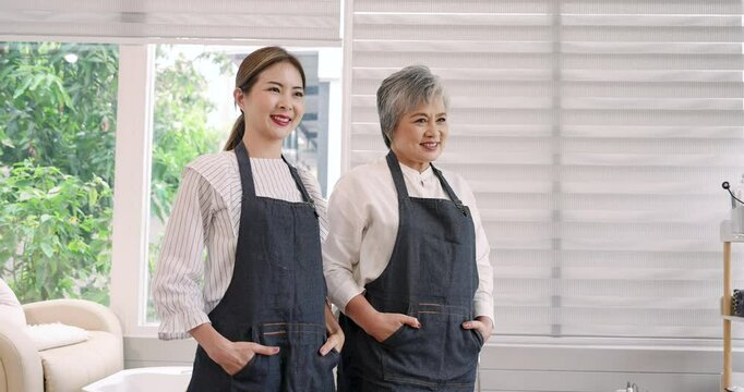 Mother and daughter Asian nail spa owners smiling warmly in a beautifully designed salon. Highlighting professionalism, close family relationship, and dedication to exceptional customer service.