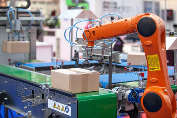 Robotic or robot arm in automated factory packing system for efficient industrial box handling and...