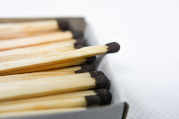 Matchsticks in a box. Matches with black heads. Matches with brown heads