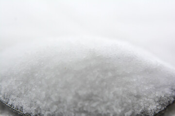 Close up salt on a white background. Salt in a spoon.