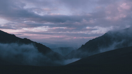 pink morning clouds and fog over the Caucasus Mountains