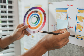 UI UX designers team working on new website wireframe in office, ux developer and ui designer use augmented reality brainstorming about mobile app interface wireframe design on desk at modern office