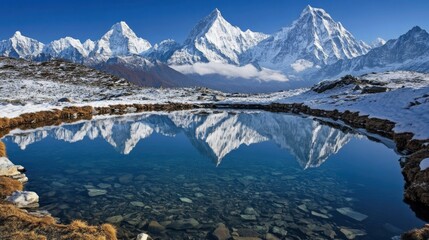 Fototapeta premium Snowcapped mountain peaks reflected in a pristine alpine lake