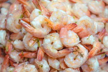 boiled red-pink shrimp with greens are scattered in a pile. High quality photo