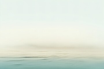 Obraz premium This tranquil shoreline features soft waves lapping against a sandy beach. The muted beige and blue colors create a soothing atmosphere, perfect for reflection or relaxation at any time of day