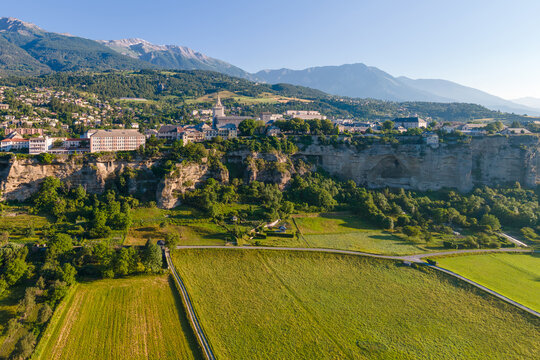 Aerial view of Le Roc cliff-top plateau and town of Embrun. Summer in Durance Valley. Hautes-Alpes, French Alps, France